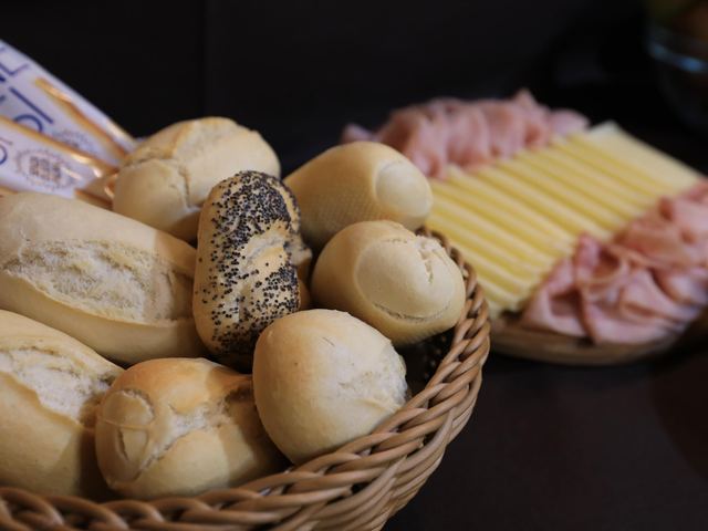Cestino di pane fresco e tagliere di formaggi e affettati per la colazione