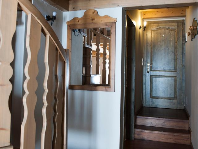 Corridoio interno con specchio in legno intagliato e scala